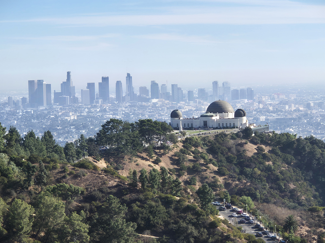 A panoramic view of the Griffith Observatory with downtown Los Angeles rising in the background, one of the city’s most iconic vistas.