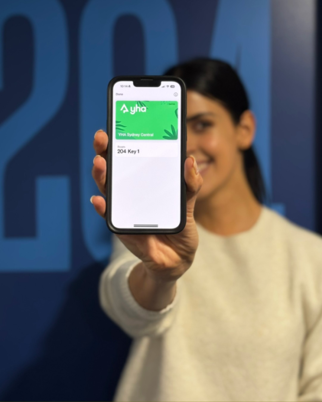 A guest showing a digital room access on a smartphone at a YHA hostel, highlighting modern and technology-driven solutions for contemporary travellers.